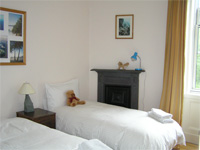 Back bedroom with original iron fireplace and a view to the shared gardens