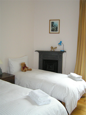 Back bedroom with original iron fireplace and a view to the shared gardens