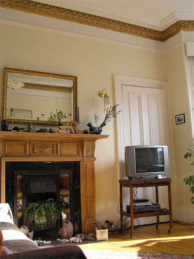 Living room, with traditional decorative fireplace & cornicing, TV, sofas