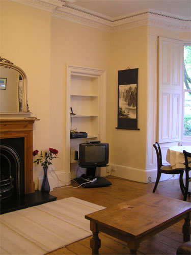 Living room, with traditional decorative fireplace & cornicing, TV, sofas