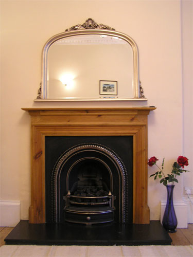 Living room, with traditional decorative fireplace & cornicing, TV, sofas