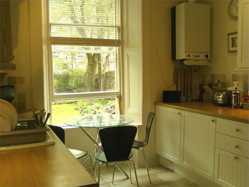 The fully fitted kitchen and table by the window overlooking the back garden